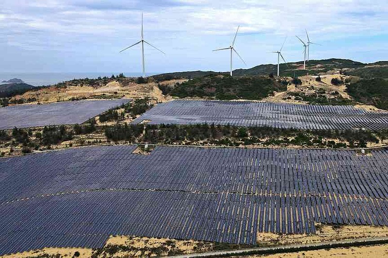 FILE - Solar panels work near wind turbines in Quy Non, Vietnam on June 11, 2023. (AP Photo/Minh Hoang, File)