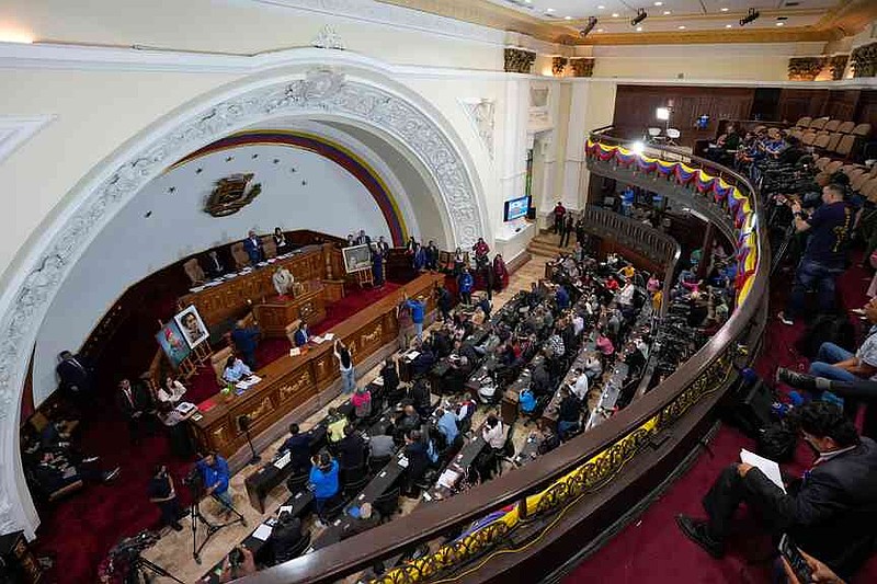 Lawmaker Giuseppe Alessandrello gives a speech during an extraordinary session at the National Assembly in Caracas, Venezuela, Monday, Dec. 22, 2025. (AP Photo/Matias Delacroix)