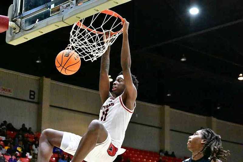 Marquise Leslie of Alexander (Douglasville, Ga.) dunks as Landen Hill of Little Rock Hall trails on the play in the second half of a King Cotton Holiday Classic game Monday, Dec. 29, 2025, at the Pine Bluff Convention Center. (Pine Bluff Commercial/I.C. Murrell)