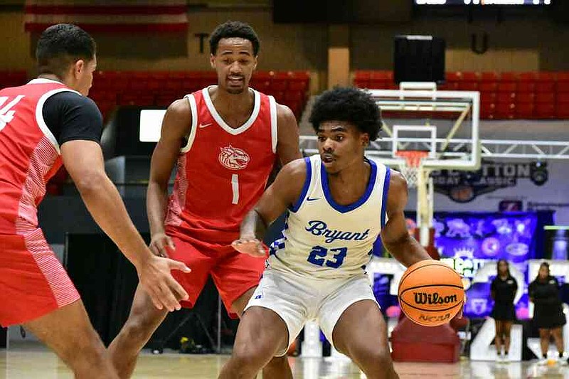 Camarion Bead of Bryant attacks the defense of Adam Hindman, left, and Brandon Bass Jr. of Windermere (Fla.) Prep in the first half of a King Cotton Holiday Classic game Tuesday, Dec. 30, 2025, at the Pine Bluff Convention Center. (Pine Bluff Commercial/I.C. Murrell)