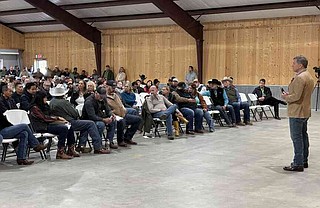 Gentner Drummond, right, attorney general for the state of Oklahoma, addresses a crowd of about 250 poultry growers gathered Thursday at the Midcounty Community Building in Westville, Okla., to discuss the state's lawsuit against poultry companies. Drummond expressed confidence the companies would settle his state's lawsuit against them. (NWA Democrat-Gazette/Doug Thompson)