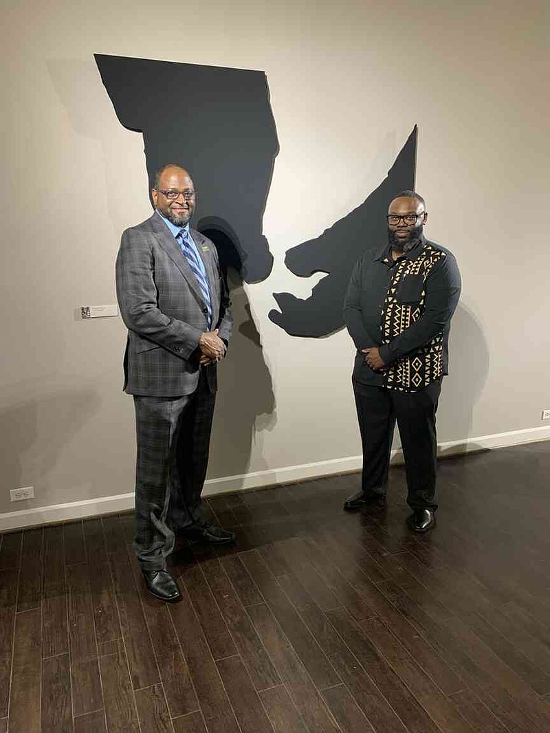 University of Arkansas at Pine Bluff Chancellor Anthony Graham, left, visits with Instructor Jonathan Rashad Wright in front of Wright's 'Grandma's Hands.' The artwork is part of Wright's Blaque exhibition at the Arts & Science Center for Southeast Arkansas. (Special to The Commercial/Mary Hester-Clifton/University of Arkansas at Pine Bluff)