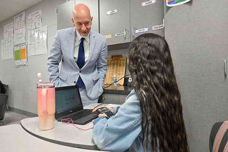 Arkansas Department of Education Secretary Jacob Oliva  watches an eighth-grade student work with math program Teach to One Roadmaps Wednesday during a classroom tour at Oakdale Middle School in Rogers. Oliva, Ken Warden, commissioner of the Arkansas Division of Higher Education, and Joel Rose, co-founder and chief executive officer of New Classrooms, visited Oakdale Elementary to view the implementation of New Classrooms program Teach to One Roadmaps, a digital math teaching tool that allows students to work through math concepts at their own pace. Visit nwaonline.com/photo for today's photo gallery.  (NWA Democrat-Gazette/Caleb Grieger)