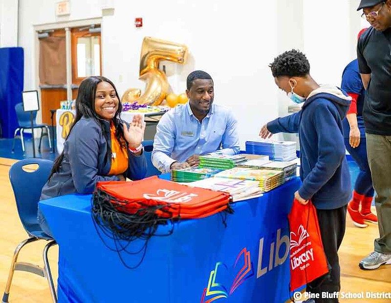 A student explores the book selection at the library's resource table during the