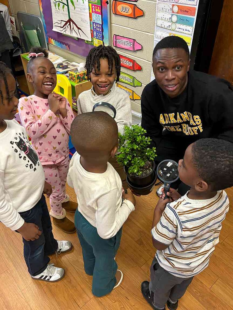 UAPB student Simon Chambo assists children Santanna Johnson, center, Makhienlee Anderson, Naiji Nowden, Michael Davenport, and Silas Rich-Cook in a plant exploration project. (Special to The Commercial/University of Arkansas at Pine Bluff)