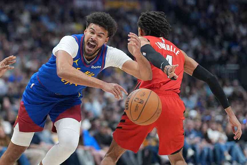 El delantero de los Denver Nuggets, Cameron Johnson, izquierda, pierde el control del balón mientras pasa al base de los Portland Trail Blazers, Matisse Thybulle, en la segunda mitad de un partido de baloncesto de la NBA el domingo 22 de marzo de 2026 en Denver. (Foto AP/David Zalubowski)
