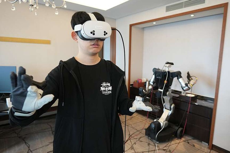 RLWRLD robotics researcher/robot pilot Jung Yong-hwa demonstrates during an interview with The Associated Press in Seoul, South Korea, Tuesday, April 28, 2026. (AP Photo/Lee ​​Jin-man)