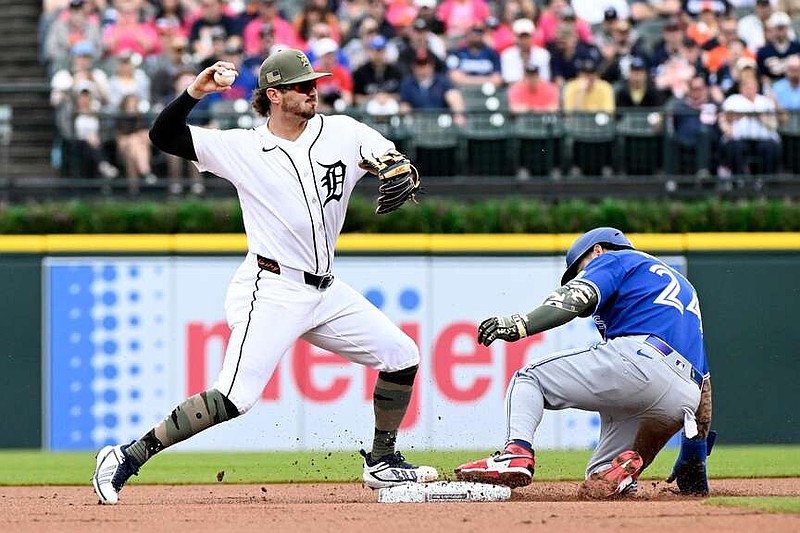 Detroit Tigers second baseman Zach McKinstry, left, throws to first base after forcing out Toronto Blue Jays' Yohendrick Pinango at second base during the first inning of a baseball game, Saturday, May 16, 2026, in Detroit. (AP Photo/Jose Juarez)