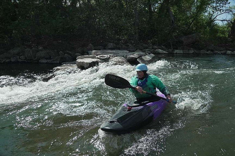 Hannah Ray J Childs kayaks at a whitewater park she helped create on the Maquoketa River, Thursday, May 7, 2026, in Manchester, Iowa. (AP Photo/Brittany Peterson)