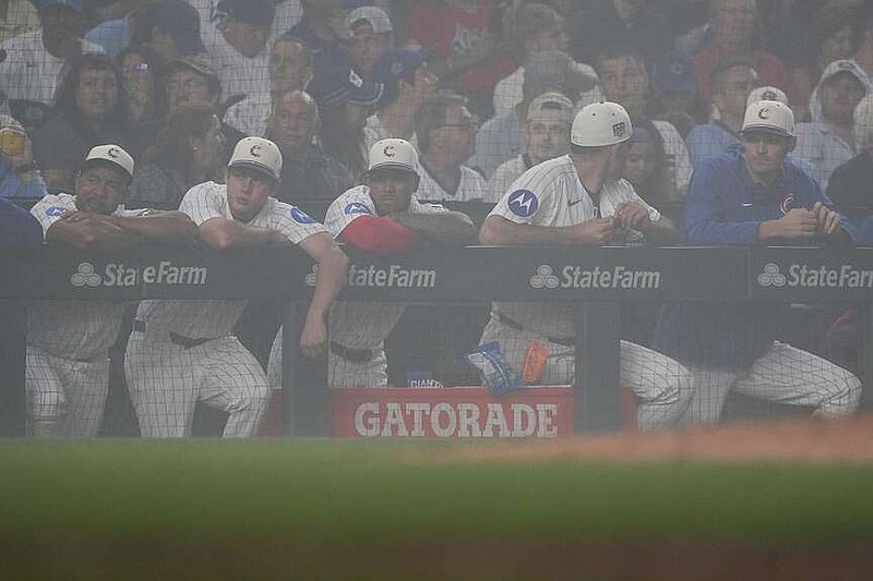 Los Cachorros de Chicago están parados en el dugout durante un retraso por niebla durante la sexta entrada de un juego de béisbol contra los Cardenales de San Luis, el sábado 4 de julio de 2026, en Chicago. (Foto AP/David Banks)