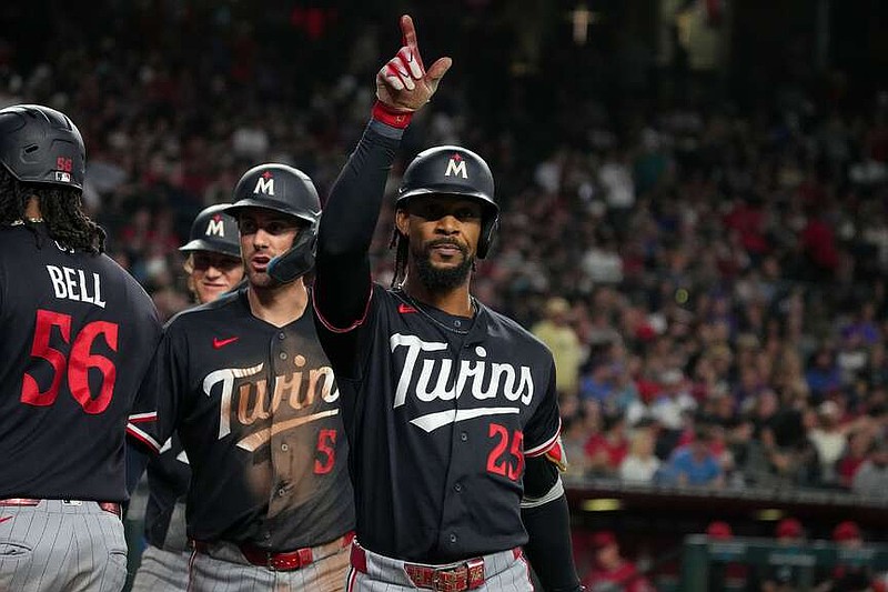 Minnesota Twins' Byron Buxton (25) celebrates after hitting a grand slam with teammates Josh Bell (56) and Ryan Kreidler (5) in the fifth inning of a baseball game against Arizona Diamondbacks Saturday, June 20, 2026, in Phoenix. (AP Photo/Darryl Webb)