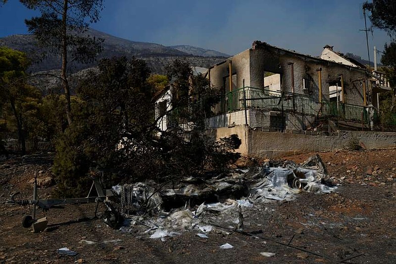 Ένα σπίτι και μια βάρκα, που καταστράφηκαν από μια πυρκαγιά, φαίνονται στο Πόρτο Γερμενό, βορειοδυτικά της Αθήνας, Ελλάδα, Δευτέρα 3 Αυγούστου 2026. (AP Photo/Πέτρος Γιαννακούρης)