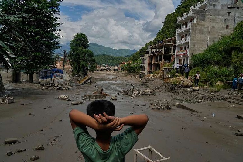 A boy looks at the devastation caused by flash flooding along the Trishuli River in Nepal's Nuwakot district, Wednesday, Aug. 26, 2026. (AP Photo/Niranjan Shrestha)