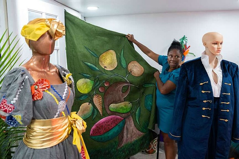 Haitian-born Clara Poteau holds up a Haitian costume for Lespri Ayiti Mas Camp, ahead of the West Indian Day Parade, Thursday, Sept. 3, 2026, in the Brooklyn borough of New York. (AP Photo/Adam Gray)