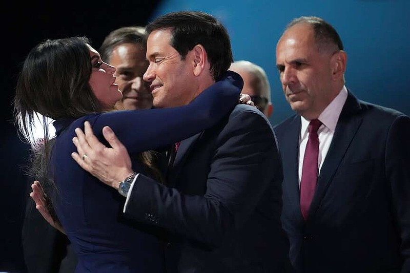 U.S. Secretary of State Marco Rubio, center, embraces U.S. Ambassador to Greece Kimberly Guilfoyle, left, as Greek Foreign Minister George Gerapetritis, right, looks on during Rubio's arrival at Eleftherios Venizelos International Airport near Athens, Greece, Tuesday, Oct. 6, 2026. (AP Photo/Mark Schiefelbein, Pool)