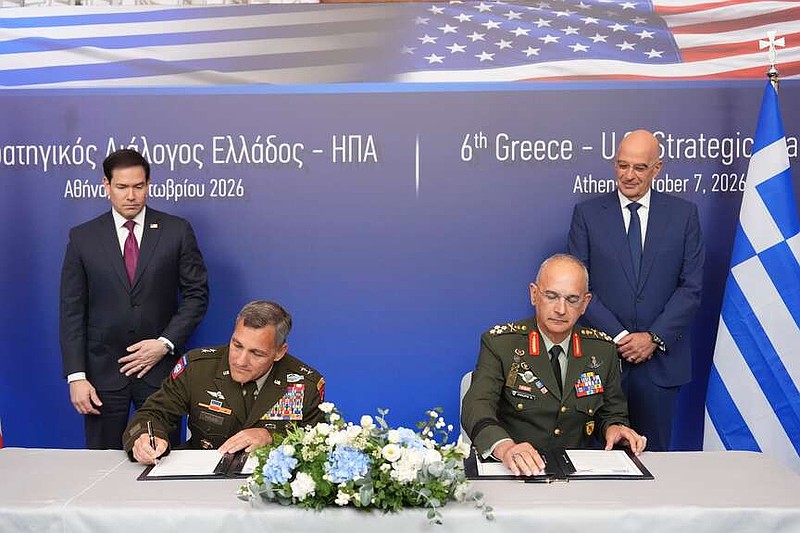 Maj. Gen. John Haas, Florida's adjutant general, second from left, and Gen. Dimitrios Choupis, chief of the Hellenic National Defence General Staff, second from right, sign documents as U.S. Secretary of State Marco Rubio, left, and Greek Defense Minister Nikos Dendias, right, look on during a signing ceremony at the Conrad Hotel in Athens, Greece, Wednesday, Oct. 7, 2026. (AP Photo/Mark Schiefelbein, Pool)