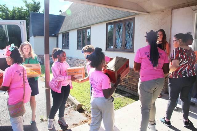Girl Scouts deliver cookies to Neighbor to Neighbor