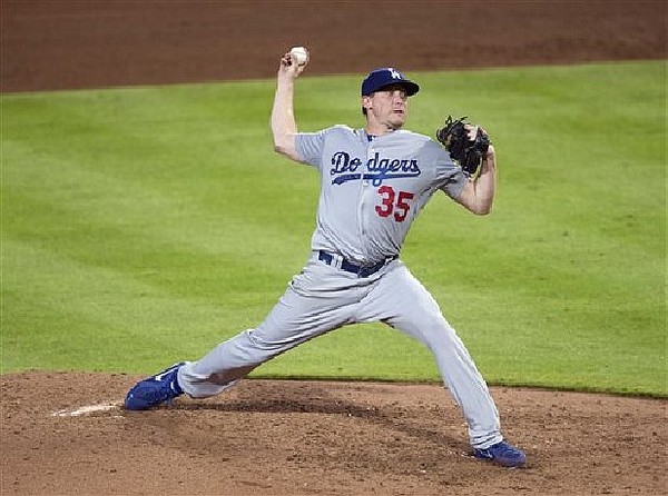 Los Angeles Dodgers' Kevin Correia bunts in Justin Turner during