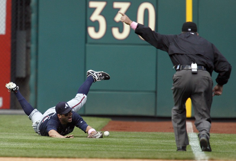 Atlanta Braves' Jeff Franceour, left, can't field a hit by Philadelphia Phillies' Miguel Cairo as first base umpire James Hoye, right, signals "fair ball" in the ninth inning of a baseball game Sunday May 10, 2009, in Philadelphia. (AP Photo/H. Rumph Jr.)
