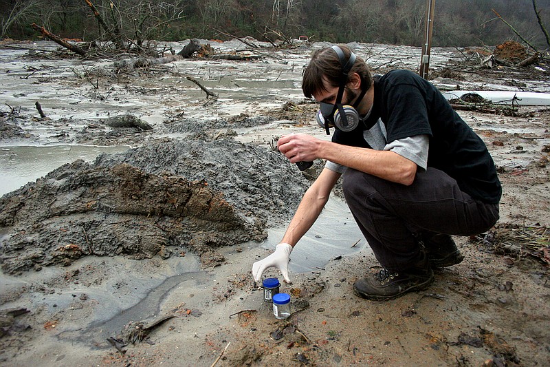 Staff Photo by Patrick Smith
United Mountain Defense volunteer Matt Landon prepares to fill another jar with sediment to be tested from the sludge left in the Swan Pond Lake Road community after the TVA coal ash spill on Dec. 22, 2008. The United Mountain Defense organization is providing their own testing records to help concerned citizens weary of TVA's information.