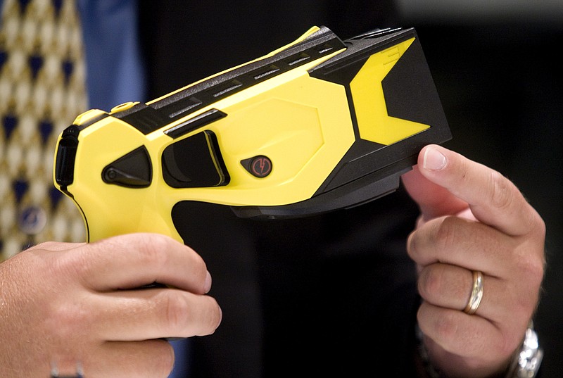 Thomas "Tom" Smith, chairman and co-founder of Taser International Inc., holds a Taser X3 Electronic Control Device, ECD, during an interview in New York, U.S., on Wednesday, July 29, 2009. Photographer: Andrew Harrer/Bloomberg