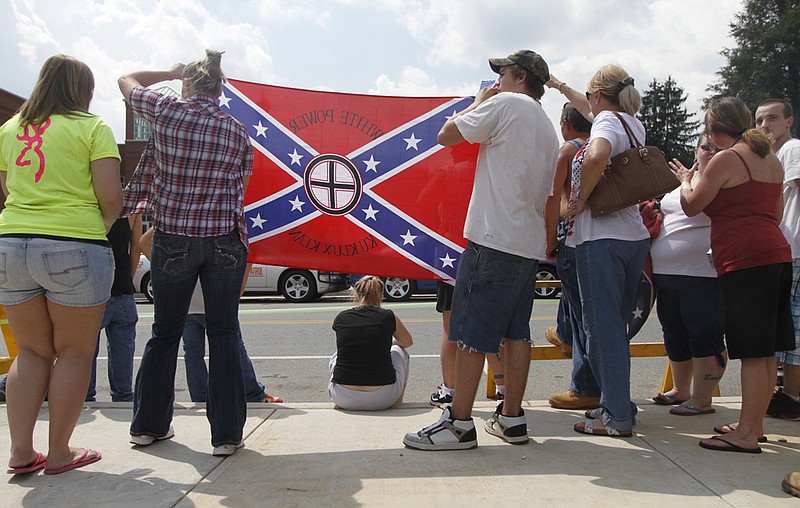 Supporters of the Ku Klux Klan hold up a white power flag during a 2010 rally in Ellijay, Ga.