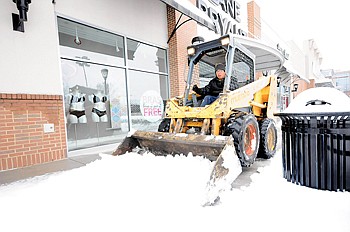 Staff Photo by Tim Barber/Chattanooga Times Free Press
Stein Construction Co. employee Carlos Botista clears snow from the sidewalk in front of Lane Bryant at the Shoppes of Hamilton Place early Tuesday.