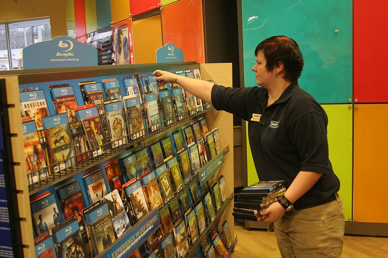 Jennifer Edge restocks Blu-ray high definition movies at Blockbuster Video.