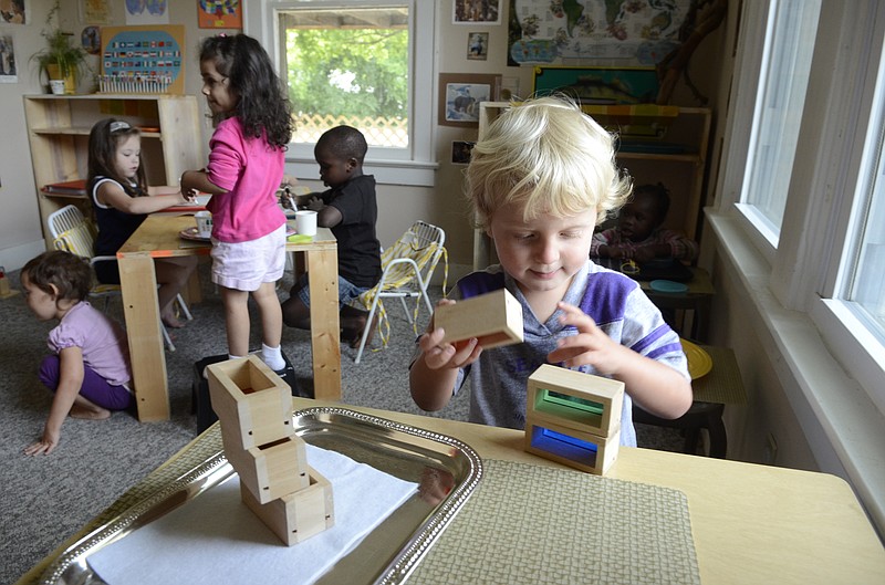 Pre-schooler Levi Davis plays with boxes with colored filters at the new Montessori School in Red Bank.