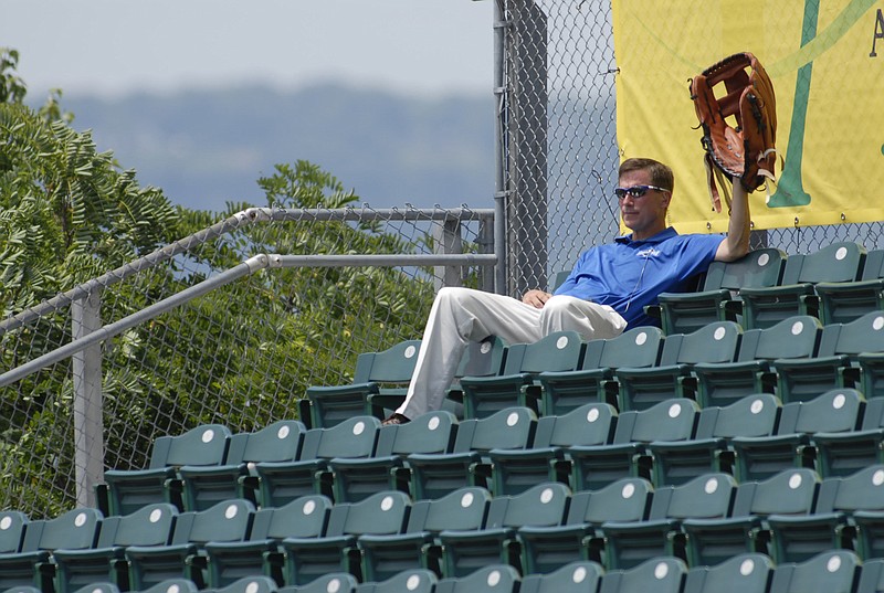 Lookouts' owner Frank Burke sits in right field with an oversize glove during a game against the Birmingham Barons. "I do it for luck," said Burke.