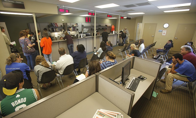 Customers wait to be seen while other wait to have their photos taken at the Cherokee Boulevard Drivers Services Center on Friday afternoon. The center is moving to a new location on Dayton Boulevard.