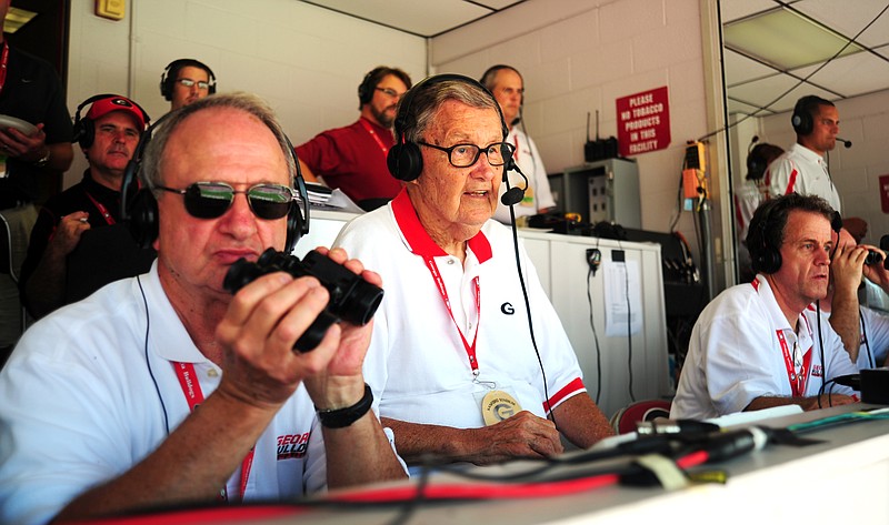 In this file photo taken Aug. 30, 2008, legendary University of Georgia play-by-play announcer Larry Munson, center, calls a game between the the Bulldogs and Georgia Southern in Athens, Ga. Munson died Sunday, Nov. 20, 2011. He was 89. A university statement said he died at his Athens home of complications from pneumonia, according to his son, Michael. (AP Photo/Athens Banner-Herald, David Manning, File)