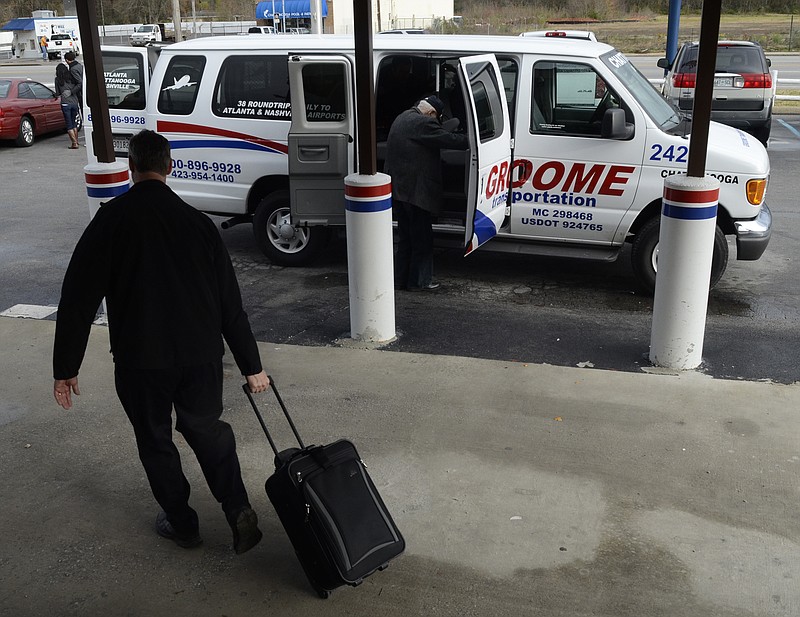 Driver Tal Larson loads luggage for a passenger at Groome Transportation in East Ridge, where the company plans to build a new building. Groome operates dozens of daily van trips that connect Chattanooga passengers to airports in Nashville and Atlanta.