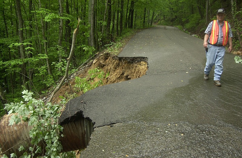 Neil Webb, Marion County Highway Department's Assistant Superintendent, walks past a washed-out portion of Sequatchie Mountain Road outside of Jasper in this file photo.