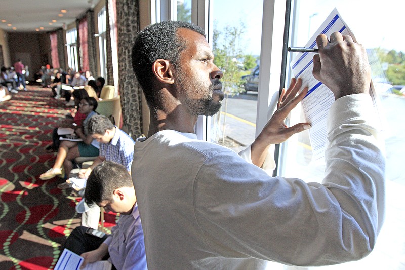 Theodore Hall fills out an application while waiting for an interview Monday during a job fair being hosted by MAU Workforce Solutions at the Holiday Inn at Hamilton Place. The positions being filled are for two Volkswagen suppliers, Gestamp and Chattanooga Seating, paying between $10-$11 per hour.