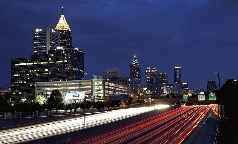 In this July 9, 2012, photograph made using a long exposure, traffic moves along Interstate 75 against the downtown skyline in Atlanta. When Georgia voters head to the polls on July 31, some of the state's political and business leaders claim they will be deciding no less than the future of the region for decades to come. Among the most contested races on the primary ballot is a transportation infrastructure referendum that would create a penny sales tax in 12 districts across the state, potentially raising billions of dollars to fund hundreds of projects over the next 10 years. But transportation has proven a controversial candidate, and the issue could be a hard sell in the weeks leading up to the election.