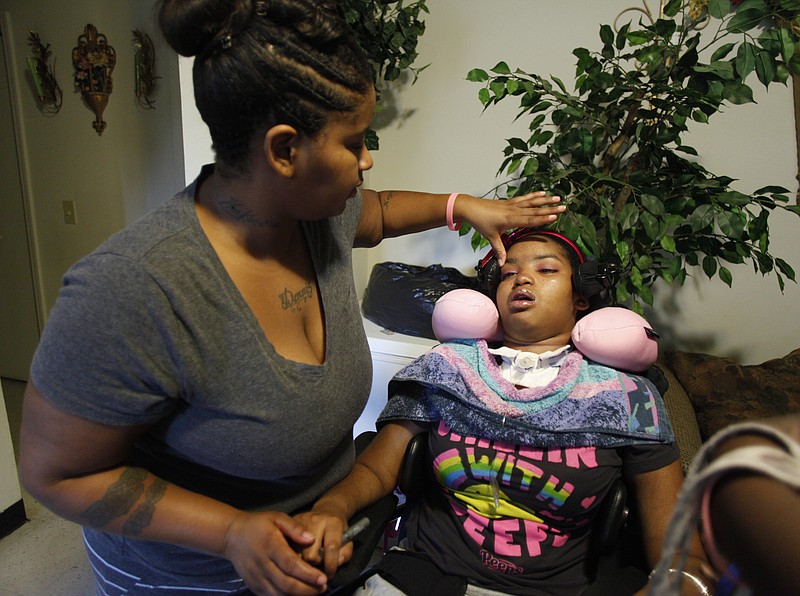 In this 2012 file photo, LeKeshia Matthews smoothes down daughter Keoshia Ford's eyebrows. Ford's family rose bright and early to take her to a doctor's appointment at Erlanger on the day this photo was taken. 