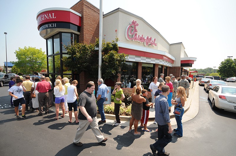 Patrons line up around the Chick-fil-A building to purchase food Wednesday at noon at the Gunbarrel Road restaurant. The drive-through line clogged traffic into the parking lot where walking customers parked in front of Kohl's department store.