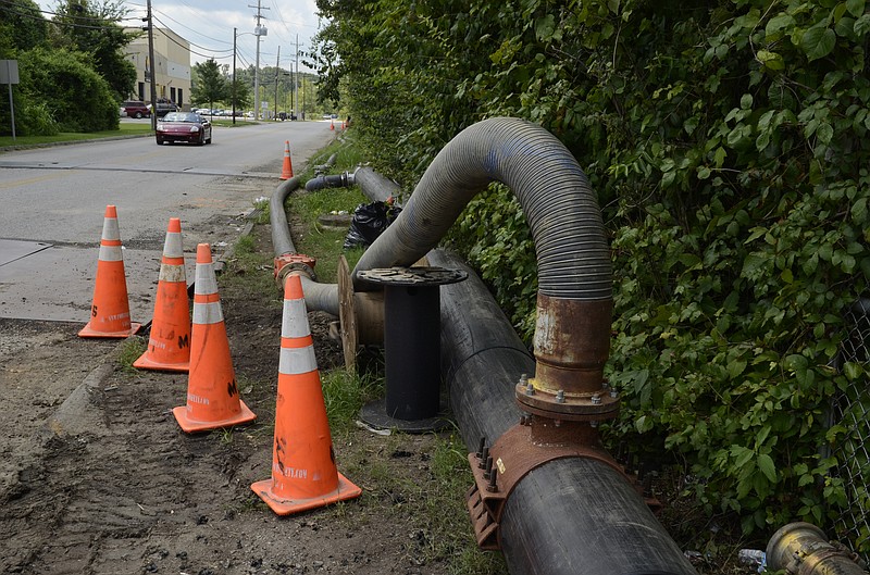 Pipes on top of the ground are seen Wednesday along Wilson Road across the street from the Emma Wheeler Homes in Alton Park. A group of activists expressed concern that water is being pumped from the former Velsicol chemical plant into the sewer system, but Chattanooga Public Works officials say they are temporarily rerouting sewers in the area so the original lines can be dried out and relined.