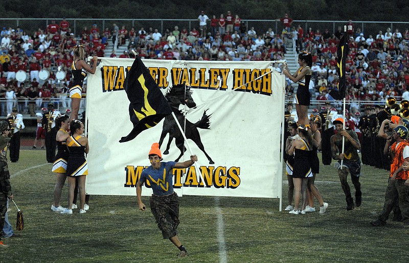 A Walker Valley fan leads in the Mustangs varsity football team into the stadium in this file photo.
