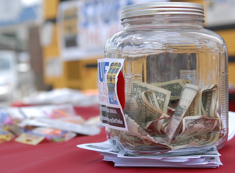 A jar of donations sits on a table at United Way of Greater Chattanooga's Stuff the Bus fundraiser at the Chattanooga Market on Sunday, August 19, 2012.