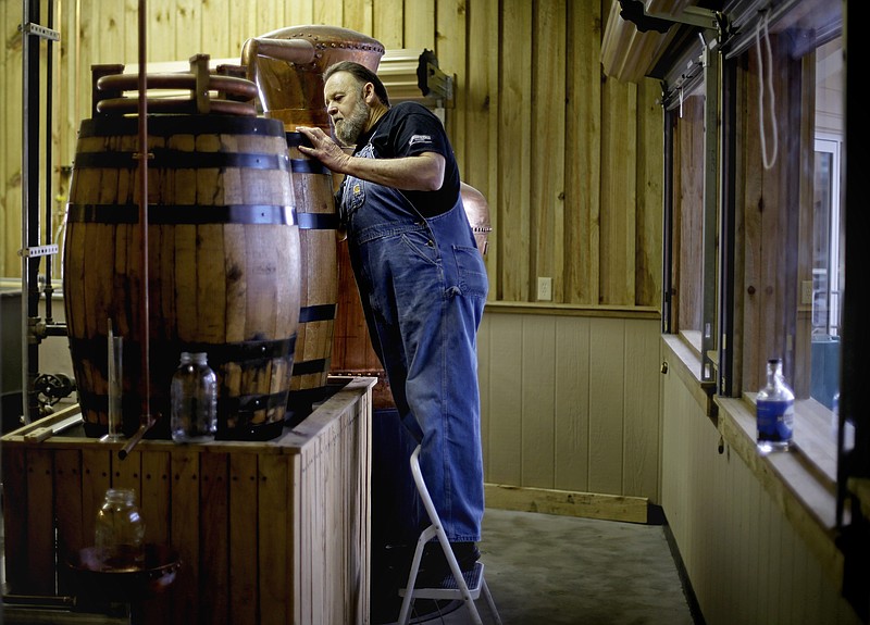 Distiller Dwight Bearden stands over a condenser barrel while making a batch of genuine corn whiskey in the Dawsonville Moonshine Distillery in Dawsonville, Ga. Distillers are making their first batches of legal liquor in this tiny Georgia town, using the town hall itself. (AP Photo/David Goldman)