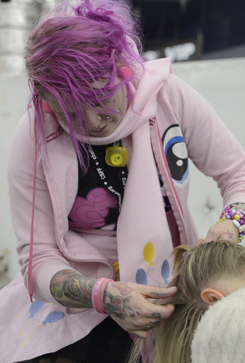 Pinkie Pell, standing, braids Gena Hall's hair.