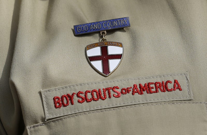 Pictured is a detail of a Boy Scout uniform worn by Brad Hankins, a campaign director for Scouts for Equality, as he responds questions during a news conference in front of the Boy Scouts of America headquarters in Irving, Texas.