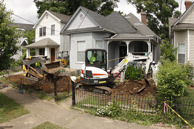 Workers remove soil contaminated with lead from the front yard of a Southside Chattanooga residence off of Mitchell Avenue last week.