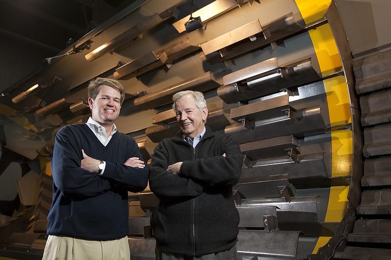 J. Don Brock, right, and his son Ben stand near a piece of machinery manufactured by their company, Astec Industries, in Chattanooga, Tenn.