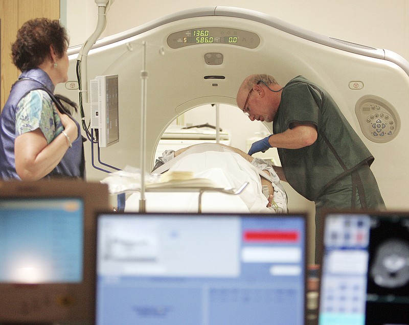 Dr. Steven Birnbaum works with a patient in a CT scanner at Southern New Hampshire Medical Center in Nashua, N.H. For the first time, government advisers are recommending screening for lung cancer, saying certain current and former smokers should get annual scans to cut their chances of dying of the disease.