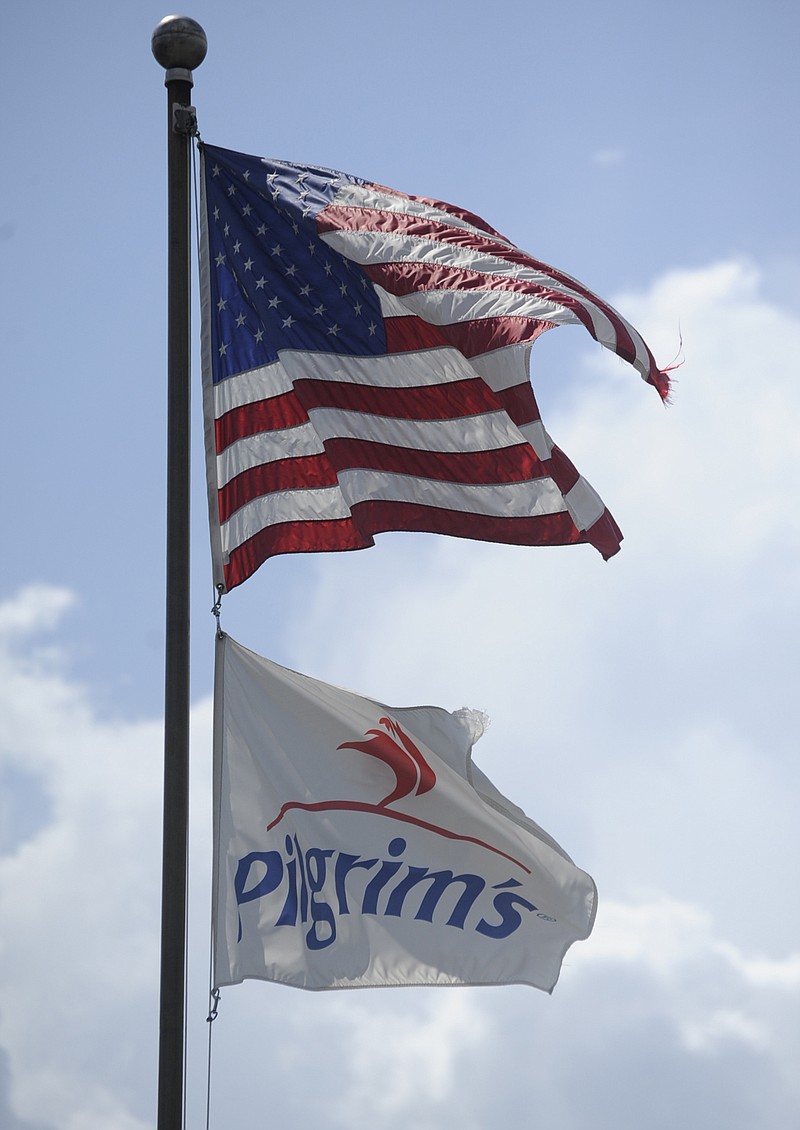 Flags fly above a Pilgrim's Pride plant.