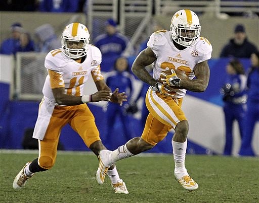 Tennessee running back Rajion Neal (20) takes the handoff from quarterback Joshua Dobbs (11) in their NCAA football game against Kentucky in Lexington, Ky., Saturday, Nov. 30, 2013. Tennessee won 27-14.