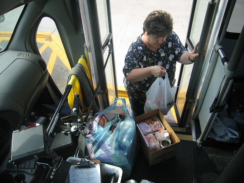 Tara Sanderson loads her groceries onto the Walker County Transit bus in the parking lot of the LaFayette WalMart. Ms. Sanderson, who doesn't drive, relies on the bus to carry her everywhere she needs to go.